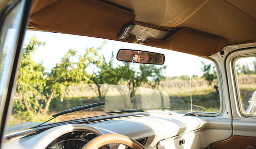 reflection of woman on automotive rear mirror thumbnail