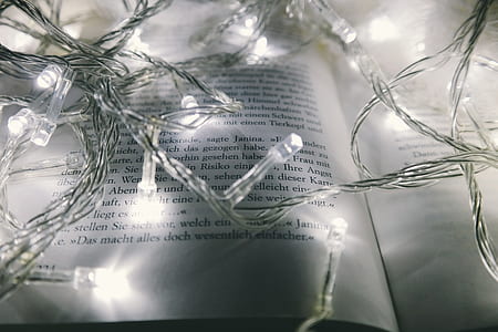 photography of turned on white string lights on opened book page thumbnail
