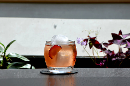 ice cube in clear drinking glass filled with red liquid thumbnail