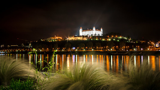 lighted building near body of water during nighttime thumbnail