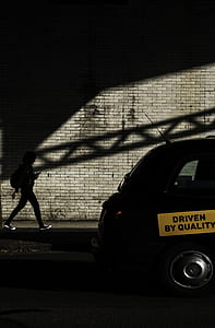 person walking towards black vehicle thumbnail