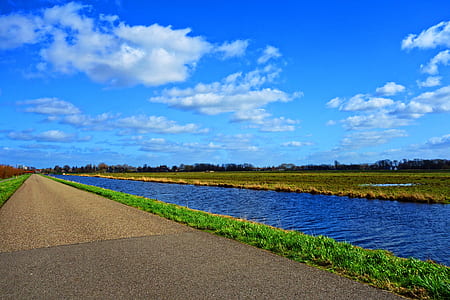 empty road near body of water at daytime thumbnail