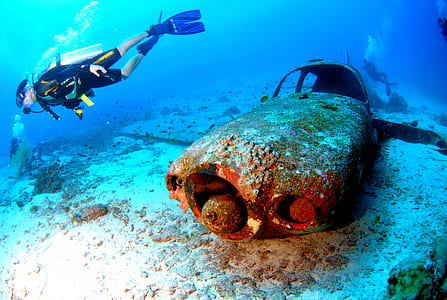 man underwater beside airplane thumbnail