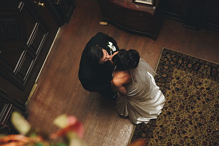 man and woman kissing standing area rug inside room thumbnail