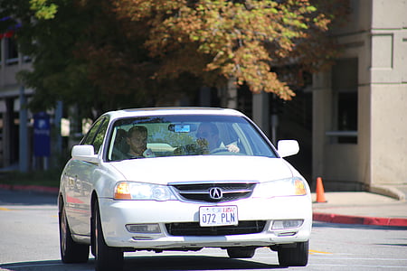 man driving white Acura TL thumbnail