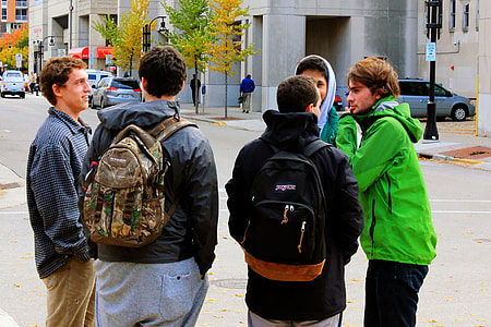 Some students standing on a street corner thumbnail