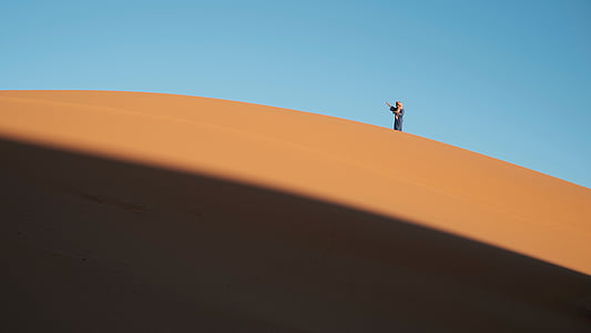 person standing on sand during daytime thumbnail