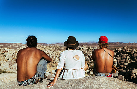two men and one woman sitting in front of rock formation outdoor thumbnail