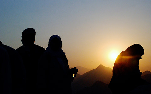 silhouette photo of people standing near mountains during sunset thumbnail