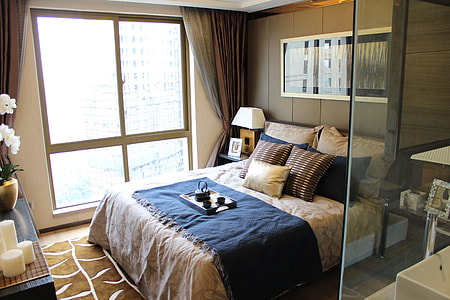 white and blue bed with pillows and white and black wooden tray thumbnail