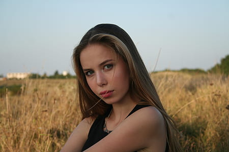 woman wearing black tank top near brown field during daytime thumbnail