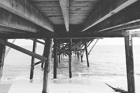 grayscale photo of the bottom a wooden dock thumbnail