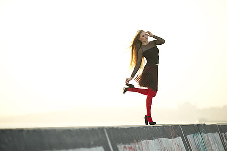 selective focus photography of woman wearing black illusion neckline long-sleeved dress posing thumbnail