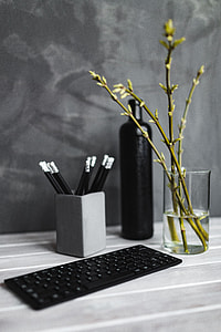 Black keyboard with pencils on a white table thumbnail