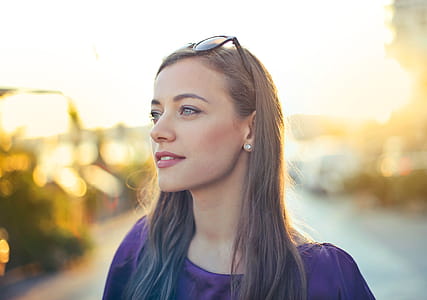 A young blonde woman wearing purple blue dress posing outdoors thumbnail