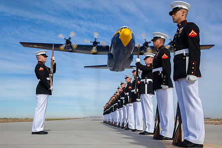 blue airplane near group of men wearing black long-sleeved shirts and white pants thumbnail