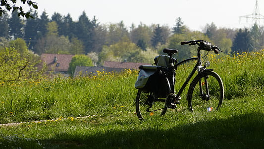 black bike parked on grass field thumbnail
