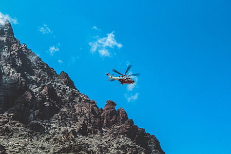 Photography of White and Red Helicopter Flying thumbnail