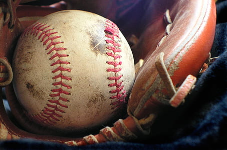 white and red baseball with brown leather baseball glove thumbnail