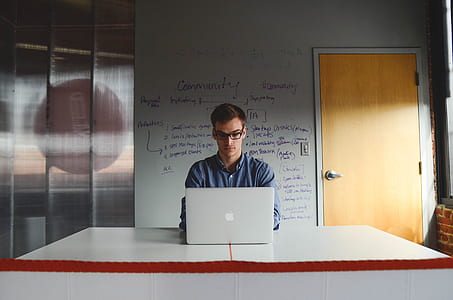 man wearing dress shirt and using MacBook on the table thumbnail