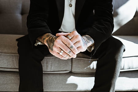 person's wearing silver-colored ring while sitting on couch thumbnail