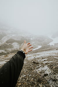 person reaching his left hand towards foggy surrounded body of water thumbnail