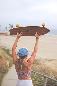 woman holding longboard during daytime thumbnail