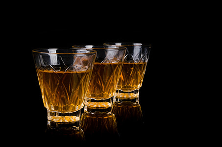 three clear crystal-cut rock glasses with brown liquid thumbnail