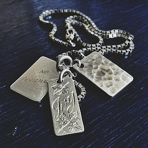 necklace with dog tags on black surface thumbnail