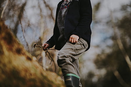 person wearing black zip-up jacket in forest thumbnail