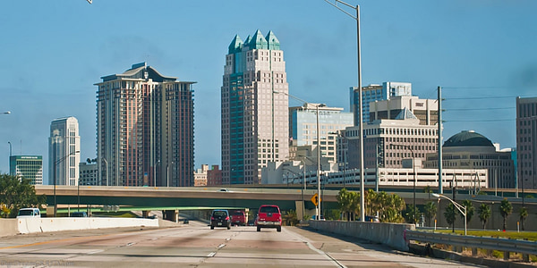 vehicle travelling towards high-rise buildings during daytime thumbnail