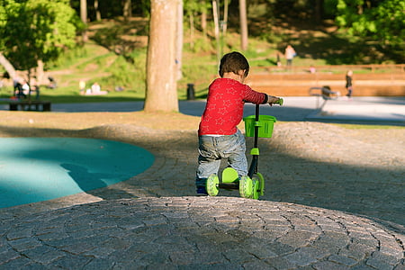 boy wearing red long-sleeved shirt riding black and green tri kick scooter thumbnail