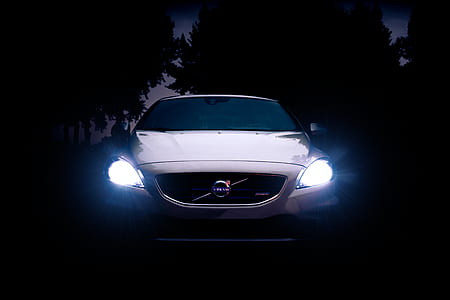 white Volvo car with headlights on thumbnail