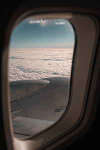 person riding on plane taking photo of white sea clouds during daytime thumbnail