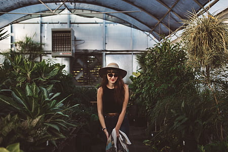 woman standing inside garden near white AC condenser unit thumbnail