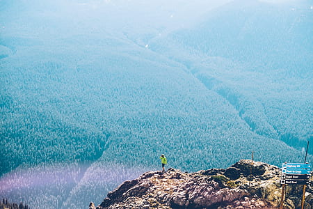 person standing on top of rock formation during day time thumbnail