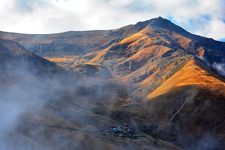 brown hills under white and blue sky thumbnail