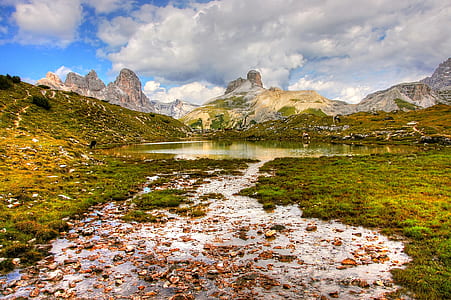 body of water in the middle of hill and mountains thumbnail