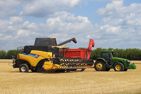 yellow and black combine harvester near John Deere tractor thumbnail