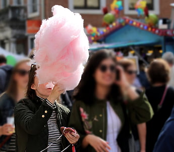woman holding cotton candy while walking thumbnail