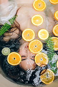 woman in bathtub with water and orange slices thumbnail