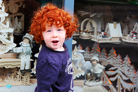 boy in blue shirt standing near sculptures thumbnail