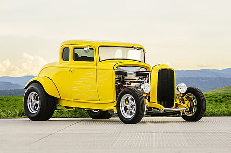 classic yellow car on gray concrete pavement at daytime thumbnail