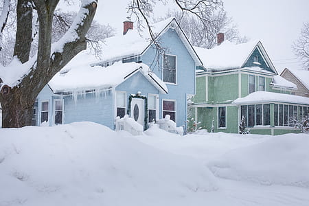 two green and blue house covered with snow during winter thumbnail