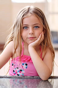 girl sitting beside table putting her hand on her chin thumbnail