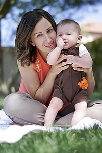 woman sitting ground holding her child during daytime thumbnail