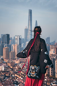 woman standing facing at high-rise building thumbnail
