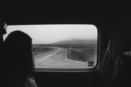 grayscale photo of person inside a vehicle looking outside on road thumbnail