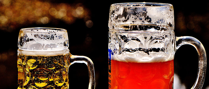 two clear glass beer mugs filled with beverages thumbnail
