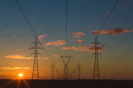 several transmission towers under blue sky thumbnail